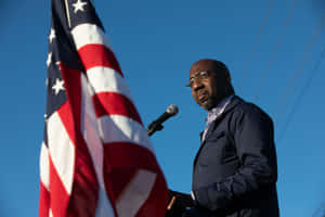 Senator Raphael Warnock Delivering A Thoughtful Speech Wallpaper