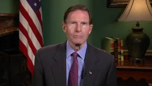 Senator Richard Blumenthal Posed Against A Green Backdrop And An American Flag Wallpaper