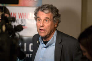 Senator Sherrod Brown Addressing The Press Conference Wallpaper