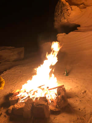 Serene Beach Campfire Under Star-studded Night Sky Wallpaper