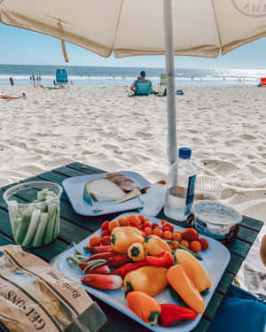 Serene Beach Picnic Setup With Sunshine Wallpaper