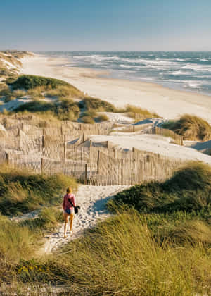 Serene Beach Walk At Sunset Wallpaper