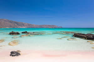 Serene Greek Beach At Sunset Wallpaper