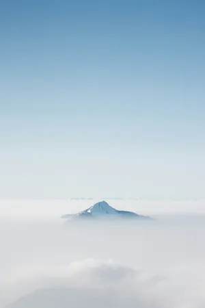 Serene Mountain Peak Above Clouds Wallpaper