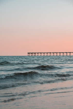 Serene Sunset Pier Beach Waves.jpg Wallpaper
