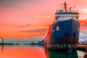 Ship In Orange Sunset Wallpaper