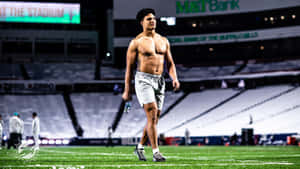 Shirtless Athlete Standingin Stadium Wallpaper