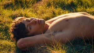 Shirtless Man Lyingin Grass During Golden Hour Wallpaper