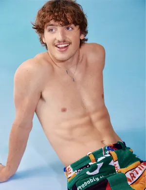 Shirtless Man With Curly Hairand Colorful Shorts Wallpaper