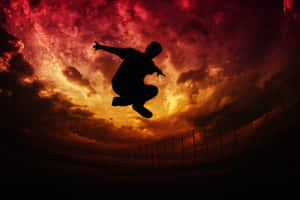 Silhouette Jump Against Sunset Sky Wallpaper