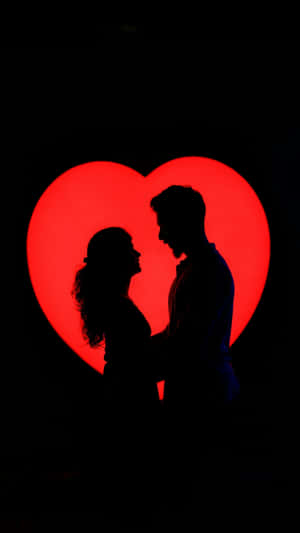 Silhouetted Lovers Against Heart Wallpaper