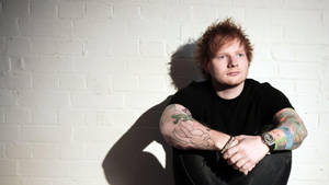 Singer-songwriter Ed Sheeran Posing In A Charming Fashion Wallpaper