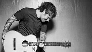 Singer-songwriter Ed Sheeran Rocking Out On Stage At A Concert Wallpaper