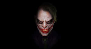 Sinister Evil Joker Grinning Menacingly In The Shadows Wallpaper