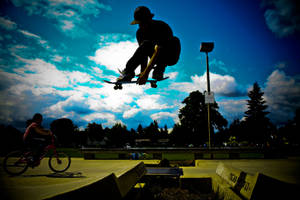 Skateboard Enthusiast Performing Tricks In Silhouette Wallpaper