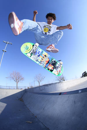 Skater Boy Showcasing His Skills In A Dramatic City Backdrop Wallpaper