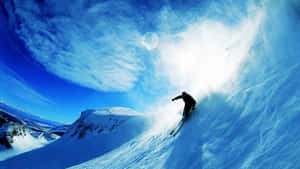 Skier Gliding Downhill Amidst Snowy Mountains Wallpaper