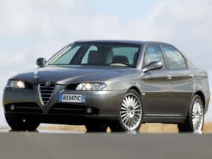Sleek Alfa Romeo 156 Driving On An Open Road Wallpaper