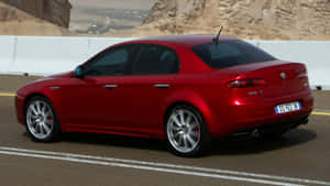 Sleek Alfa Romeo 159 Cruising On The Road Wallpaper