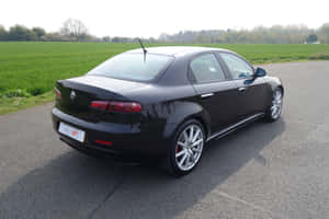 Sleek Alfa Romeo 159 On The Open Road Wallpaper