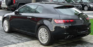 Sleek Alfa Romeo Brera On A Picturesque Road Wallpaper