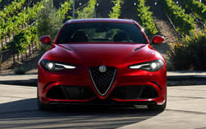 Sleek Alfa Romeo Giulia Driving On Mountain Road Wallpaper