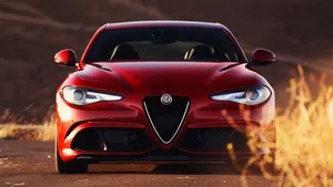 Sleek Alfa Romeo Giulia In Vibrant City Background Wallpaper