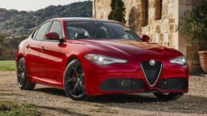 Sleek Alfa Romeo Giulia On A Scenic Mountain Road Wallpaper