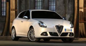 Sleek Alfa Romeo Giulietta Gliding Through City Streets Wallpaper