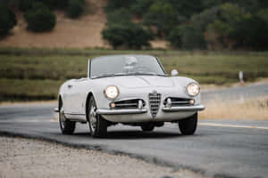 Sleek Alfa Romeo Spider In A Breathtaking Scenic Backdrop Wallpaper