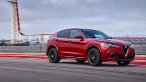 Sleek Alfa Romeo Stelvio Cruising Through The Scenic Mountain Road. Wallpaper