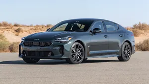 Sleek And Powerful Black Kia Stinger On The Road Wallpaper