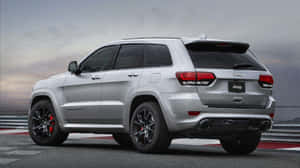 Sleek And Powerful Jeep Grand Cherokee In Wilderness Wallpaper