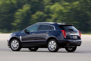 Sleek And Sophisticated Cadillac Srx On The Road Wallpaper