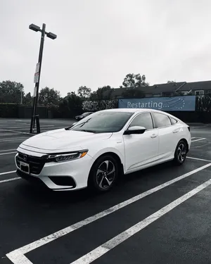 Sleek And Sophisticated Honda Insight On A Scenic Urban Road Wallpaper