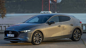 Sleek And Stylish 2021 Mazda 3 Hatchback Under The Cloudy Sky Wallpaper
