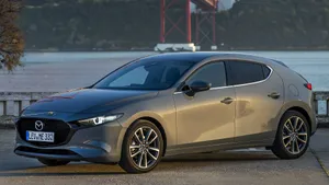 Sleek And Stylish 2021 Mazda 3 Hatchback Under The Cloudy Sky Wallpaper