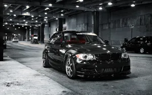 Sleek And Stylish Bmw 1 Series Parked On A City Street Wallpaper