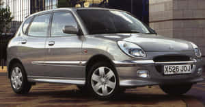 Sleek And Stylish Daihatsu Sirion Parked Outdoor Wallpaper