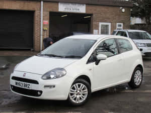 Sleek And Stylish Fiat Punto Driving On Open Road Wallpaper