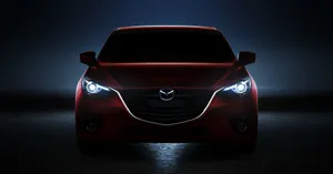 Sleek And Stylish Mazda 3 Hatchback Against A Cityscape Wallpaper