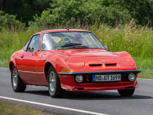 Sleek And Stylish Opel Gt Under A Cloudy Sky Wallpaper