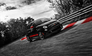 Sleek Black Abarth 595 On City Streets Wallpaper