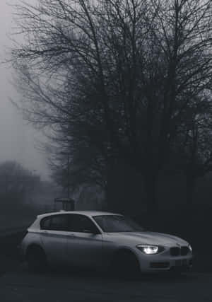 Sleek Black And White Car On Urban Road Wallpaper