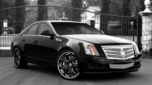 Sleek Black Cadillac Cts On The Road Wallpaper
