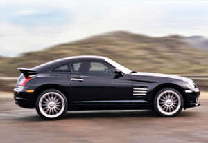 Sleek Black Chrysler Crossfire Parked On Asphalt Wallpaper