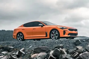 Sleek Black Kia Stinger On The Road Wallpaper