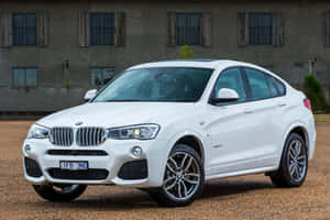 Sleek Bmw X4 In Motion On A Scenic Road Wallpaper