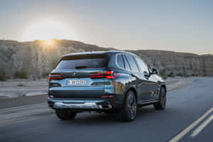 Sleek Bmw X5 Showcasing Its Elegant Design And Power On An Open Road. Wallpaper