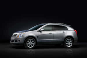 Sleek Cadillac Srx Driving On Scenic Route Wallpaper